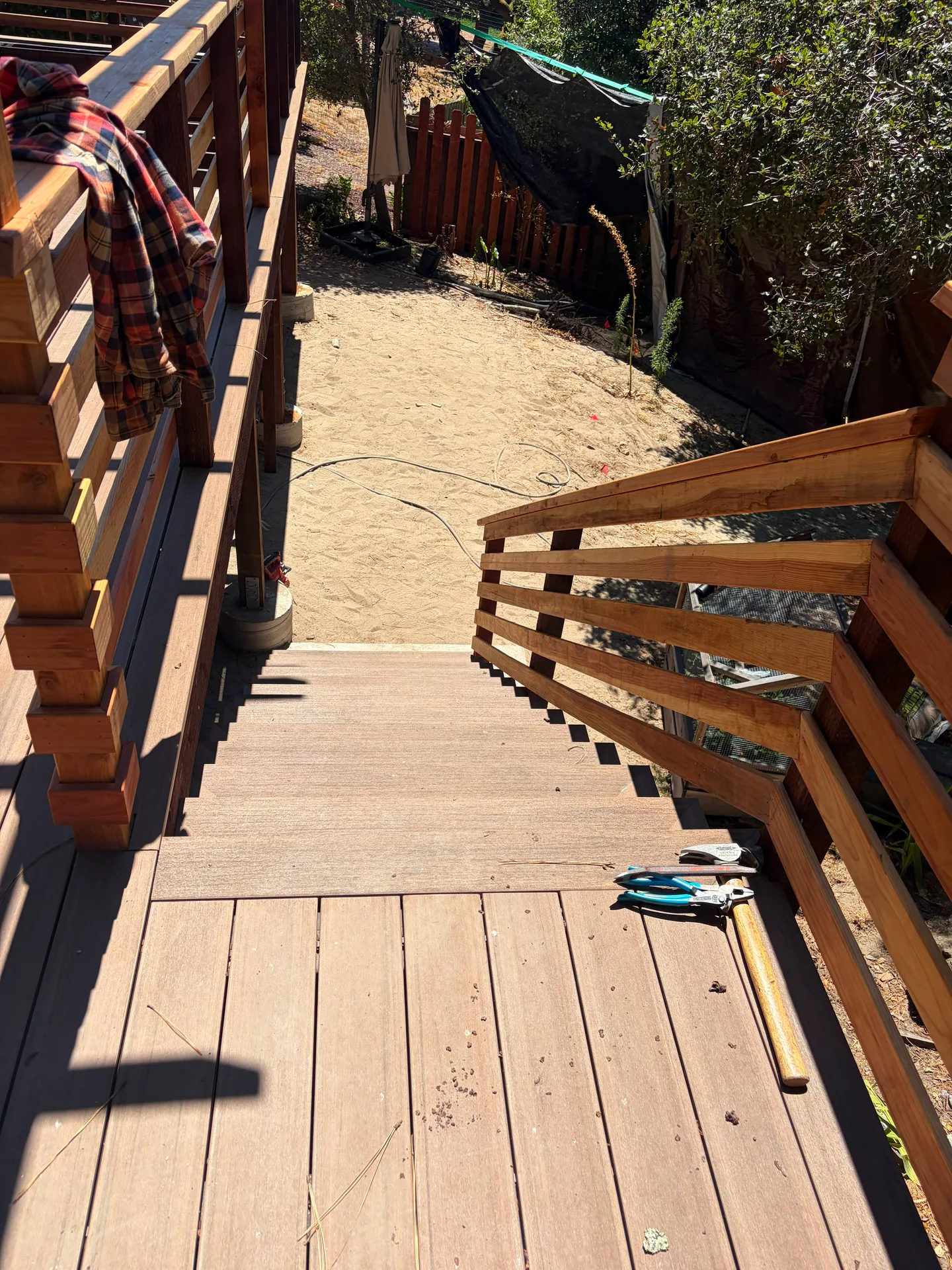 Deck stairs with slat railing leading to the yard