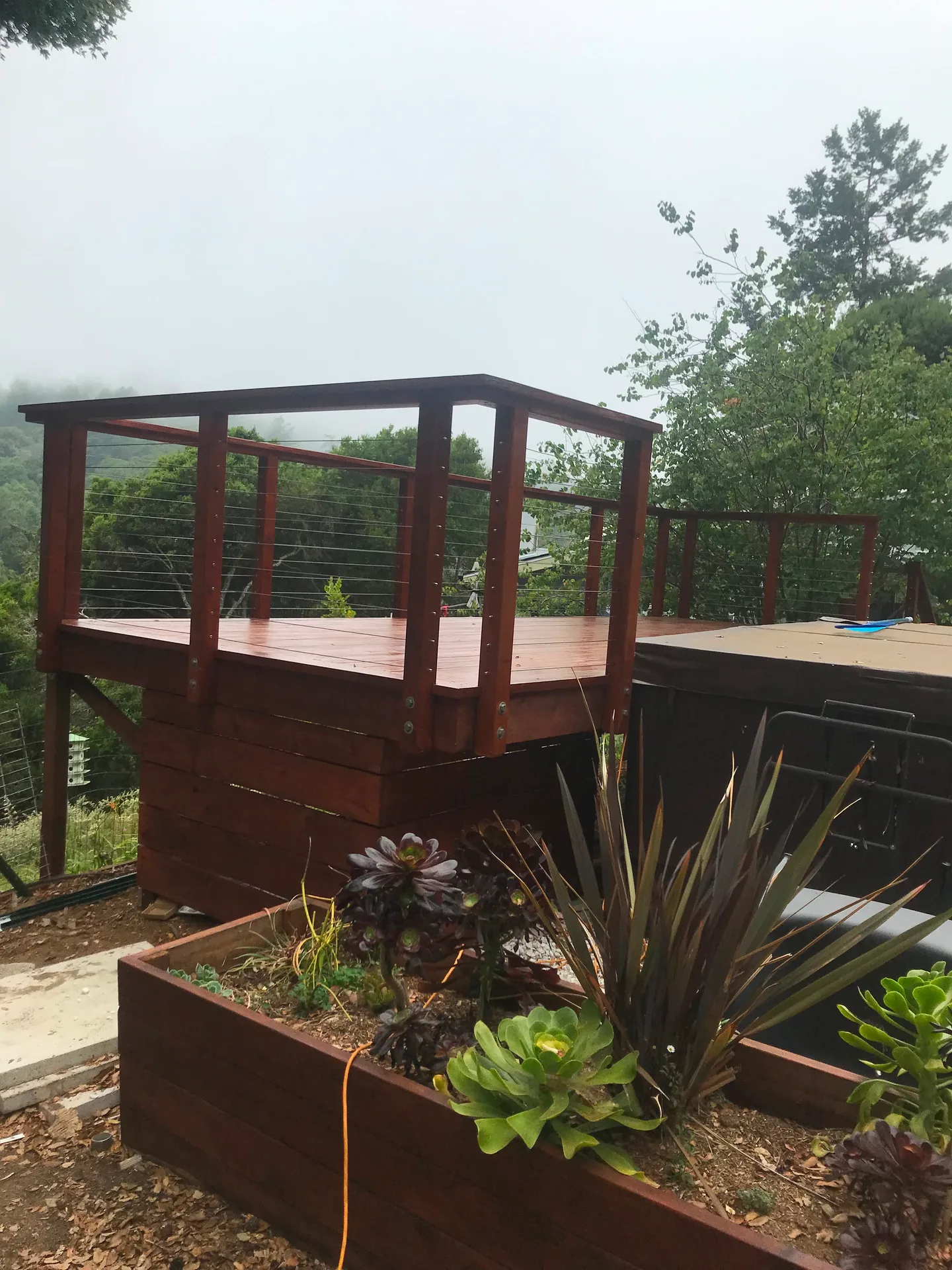 Finished deck with cable railing near a hot tub