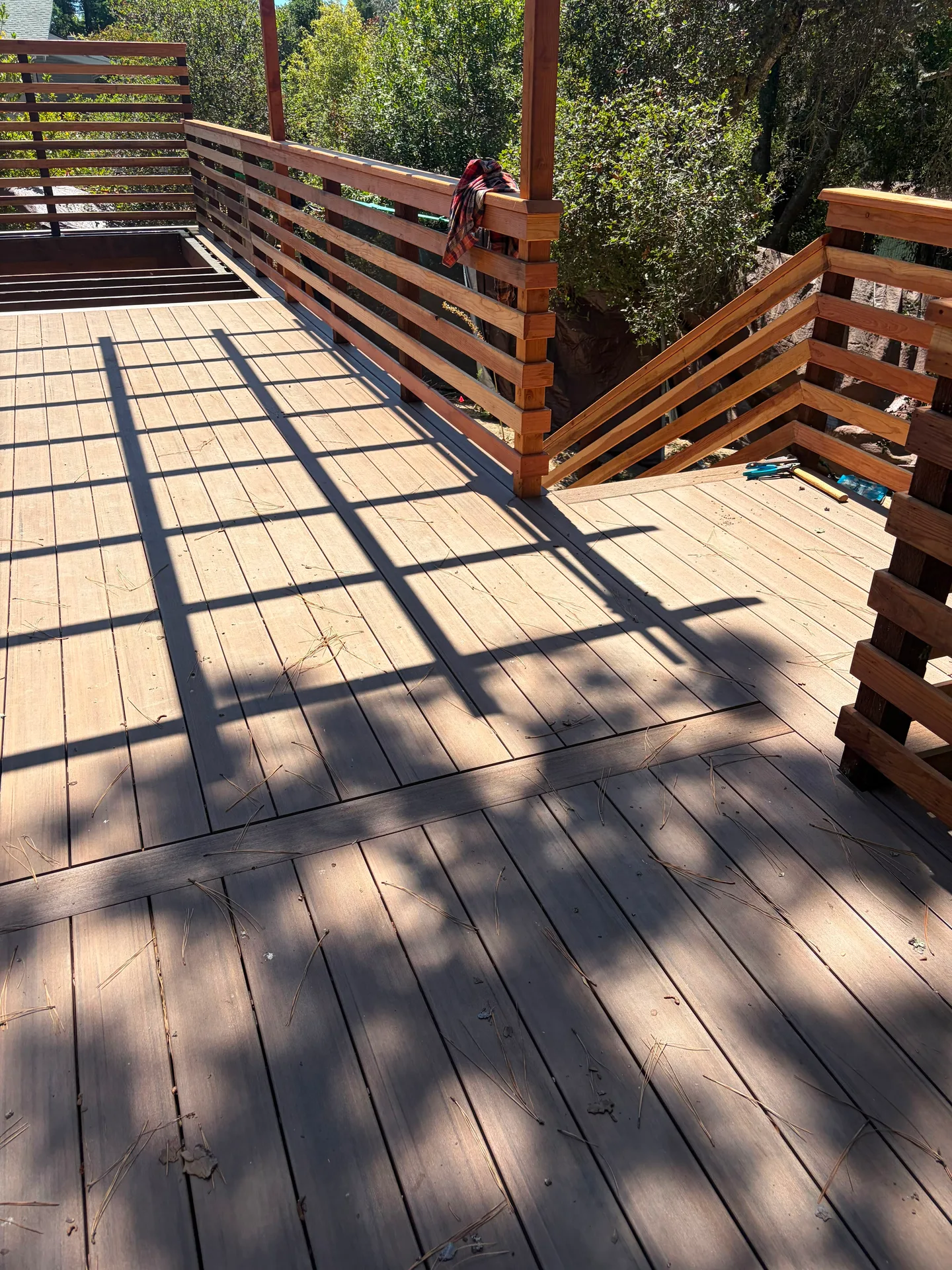 Finished wood deck with stairs and slat railing built by Double Y Framing